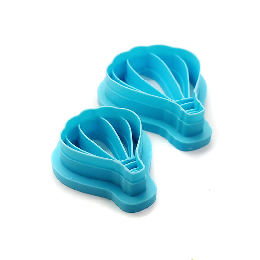 Two blue hot air balloon-shaped clay cutters against a white background.