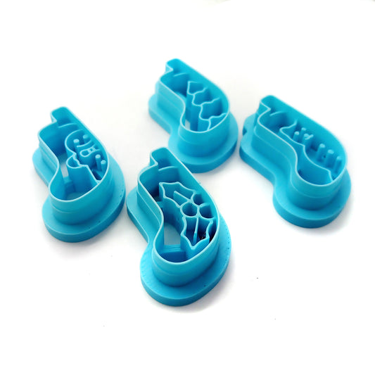 Set of four blue clay cutters, Christmas stocking scenes on a white background