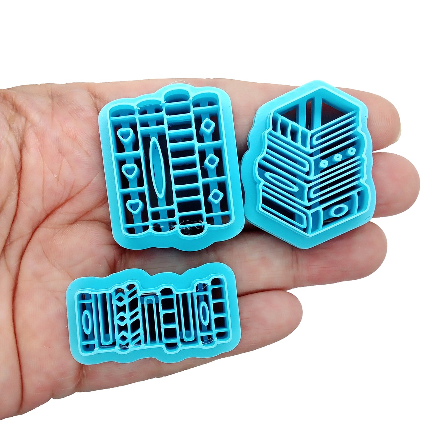 Set of blue clay cutters shaped like books inn a hand