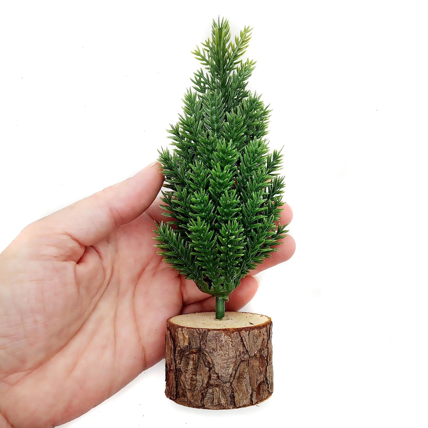 Scale of miniature Christmas tree with hand.