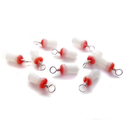 Little glass bead charms in the shape of fly agaric mushrooms.