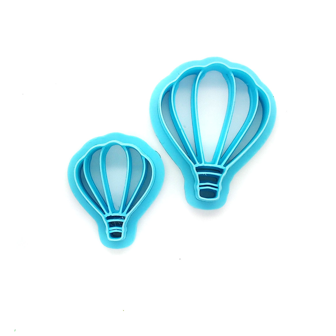 Two blue hot air balloon-shaped clay cutters against a white background.