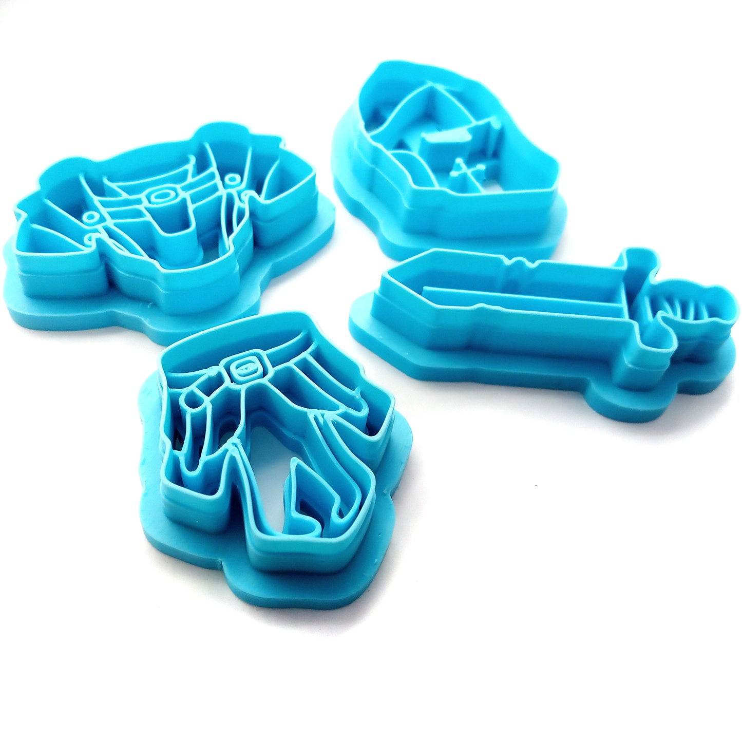 Set of blue clay cutters shaped like a helmet, sword, and armor on a white background.