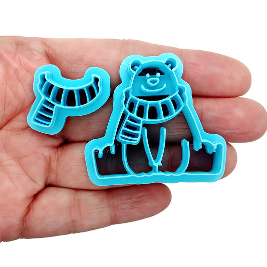 Blue bear-shaped clay cutter held in a hand against a white background