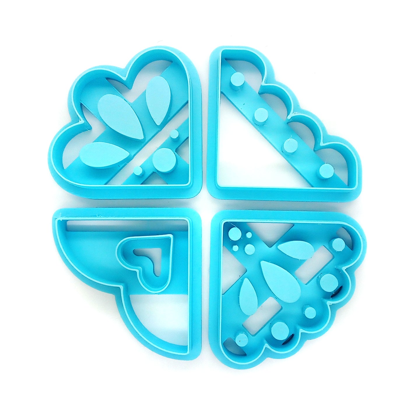 Set of four blue clay cutters with floral and geometric designs on a white background