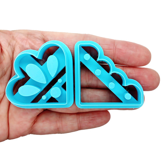 Blue clay cutters for decorative corners held in a hand on a white background