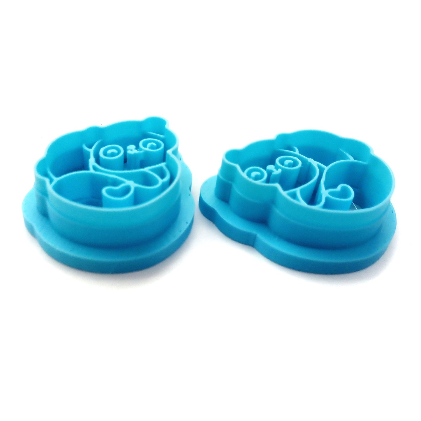 Two blue panda-shaped clay cutters on a white background