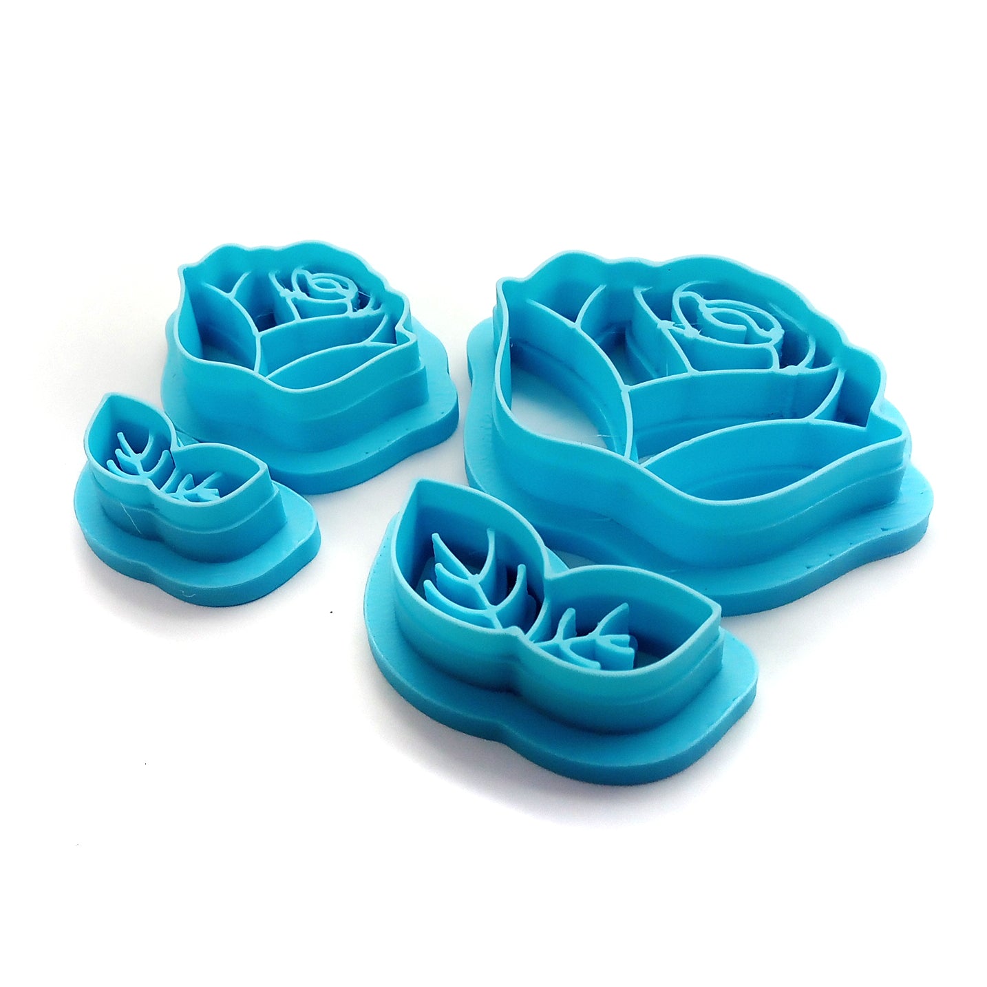 Set of blue rose-shaped clay cutters on a white background