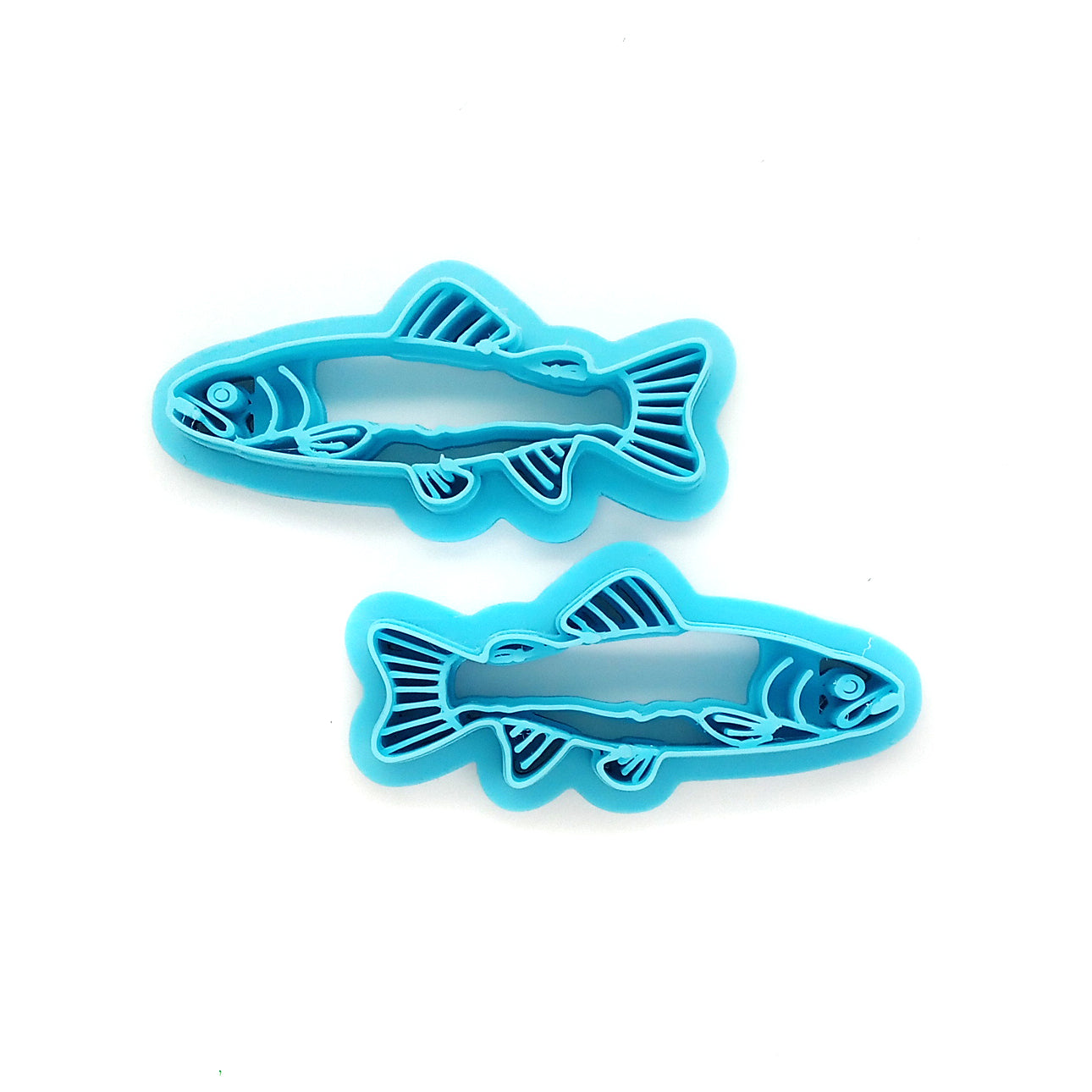 Two blue fish-shaped (salmon) clay cutters on a white background