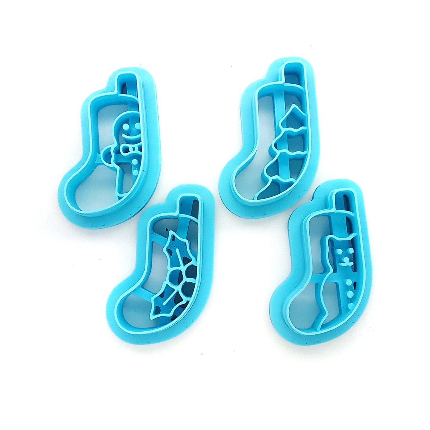 Set of four blue clay cutters, Christmas stocking scenes on a white background