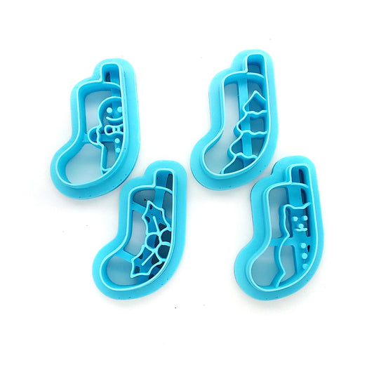 Set of four blue clay cutters, Christmas stocking scenes on a white background