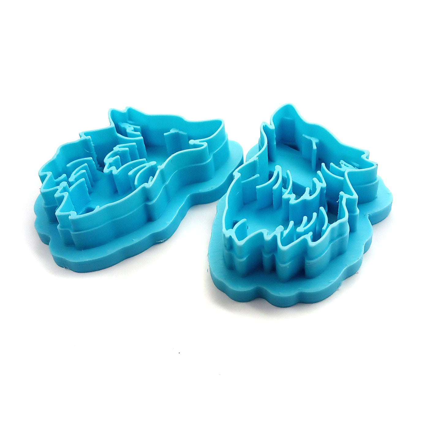 Two blue wolf-shaped clay cutters on a white background