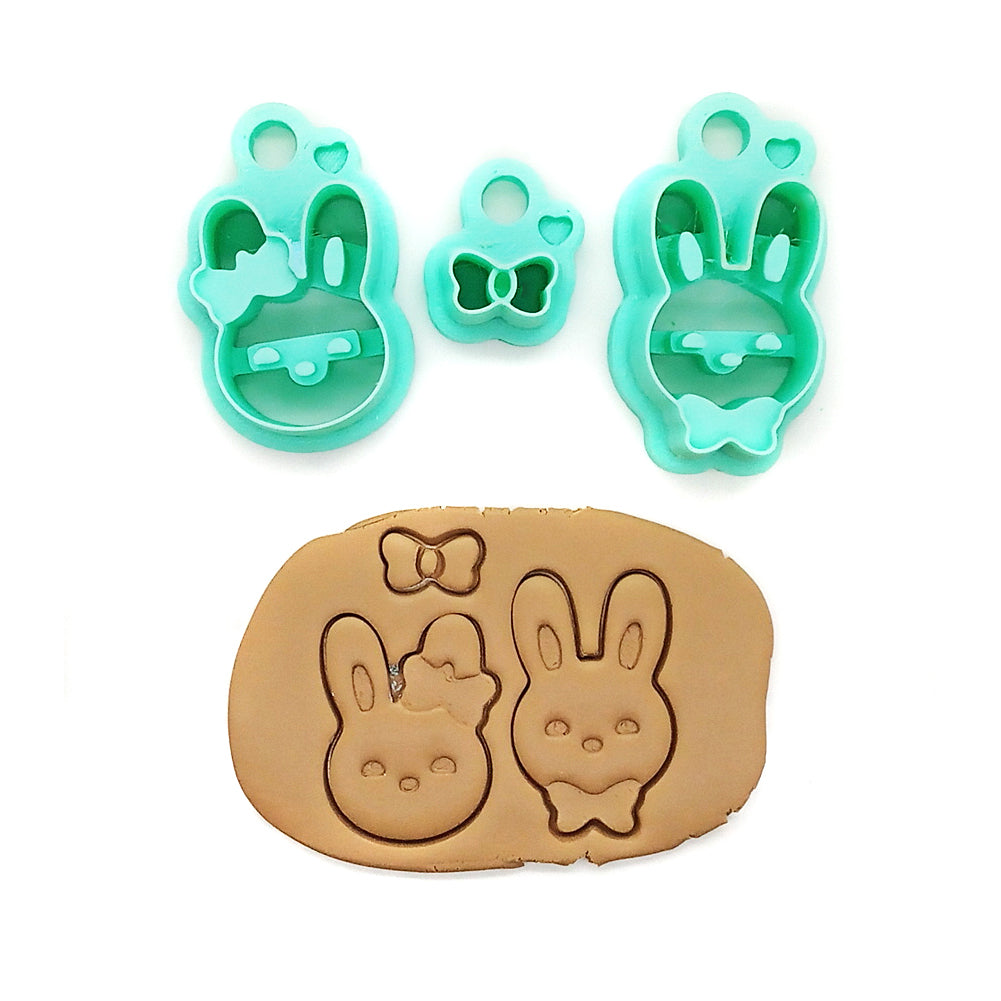 Set of clay cutters shaped like bunnies and a bow on a white background
