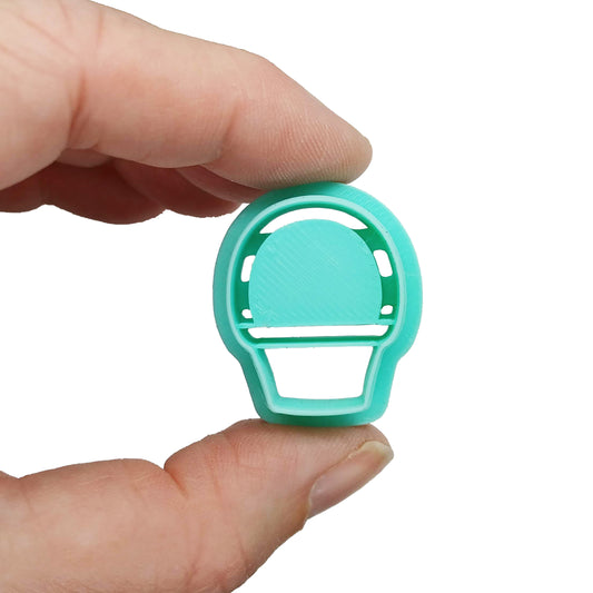 Small Easter basket clay cutter held in fingers.