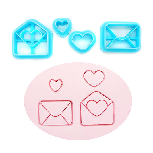 Set of blue clay cutters shaped like hearts and envelopes on a white background