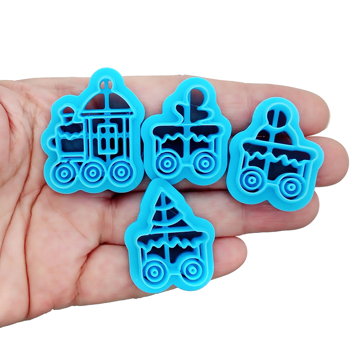 Four bright blue plastic train-shaped clay cutters