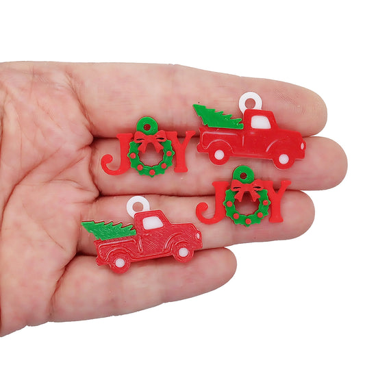 Christmas charms in red and green: trucks carrying Christmas trees, and joy shapes with green wreaths.