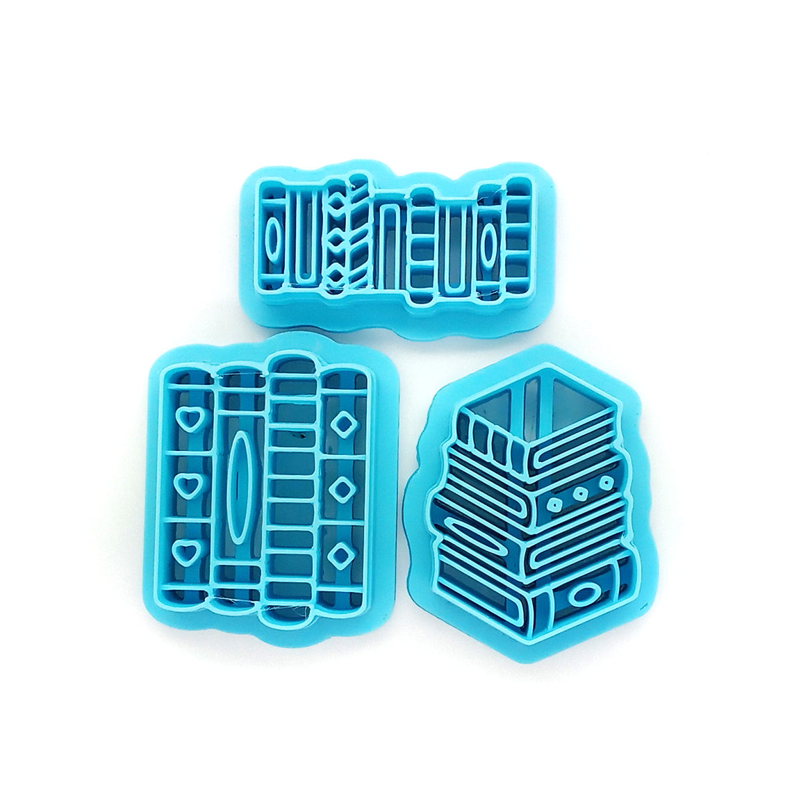 Set of blue clay cutters shaped like books on a white background
