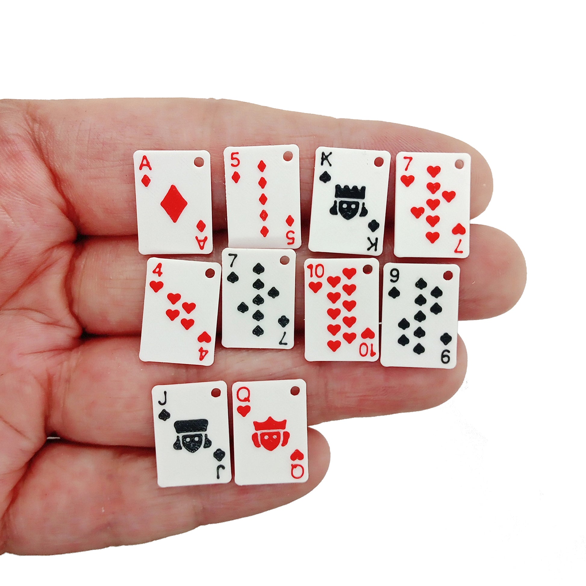 Tiny playing card charms - assortment of hearts, diamonds, clubs and spades with red backs, held in hand.