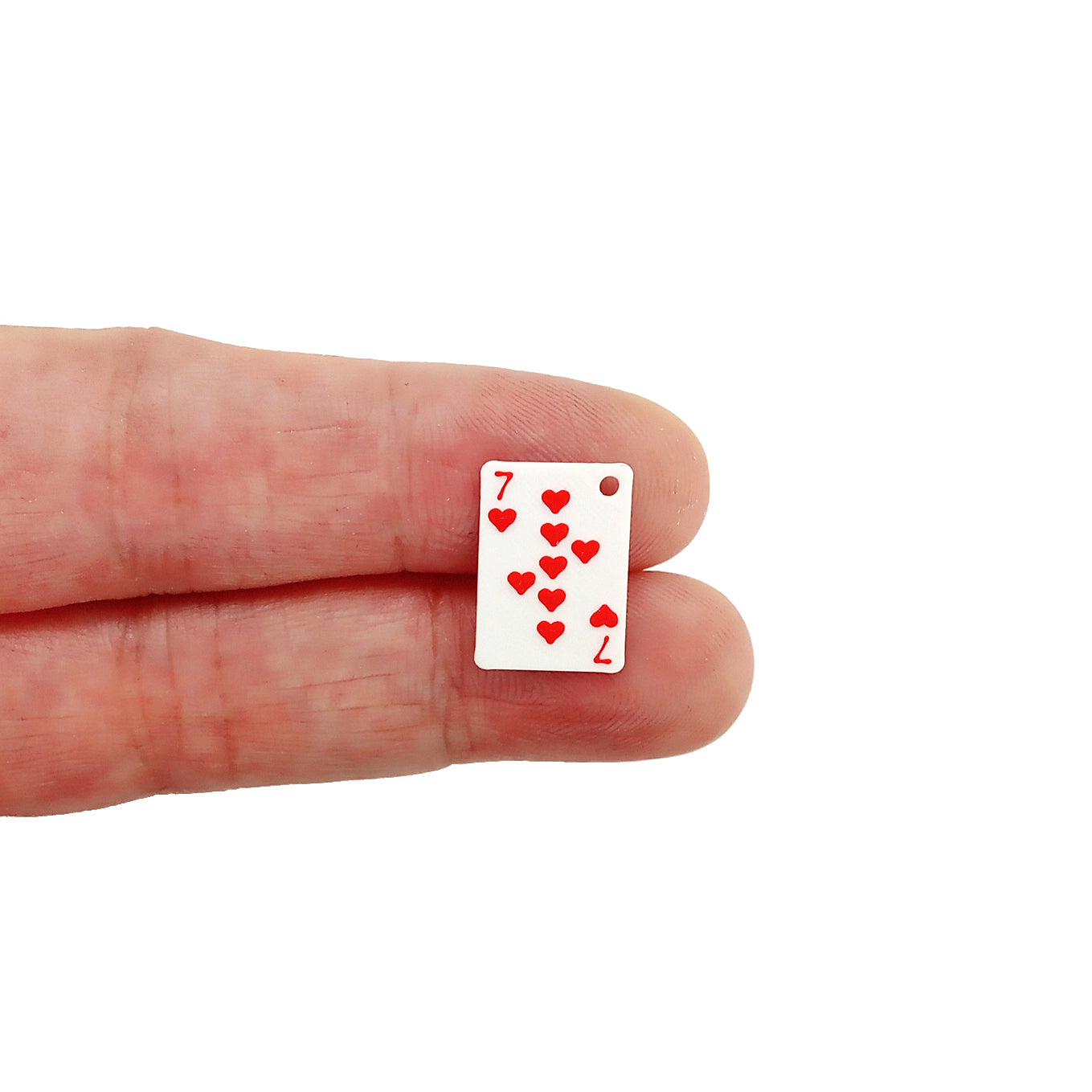 Small playing card charm - 7 of hearts held on fingers on a white background