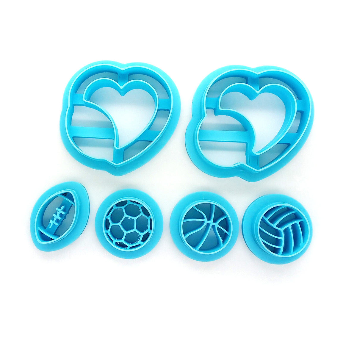 Set of clay cutters with large hearts holding sports balls