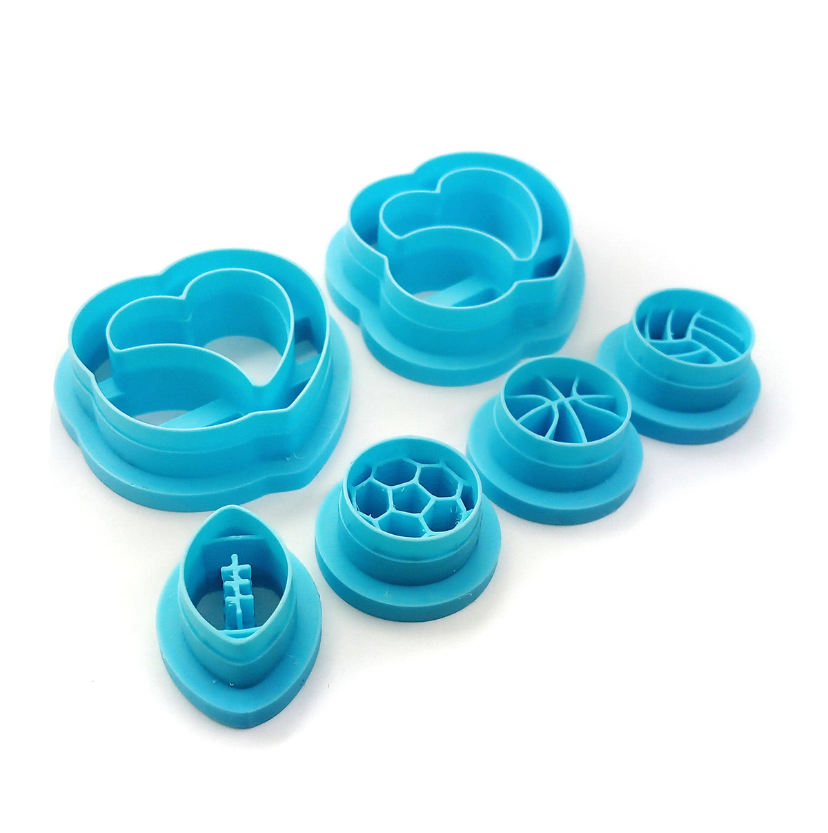 Set of clay cutters with large hearts holding sports balls