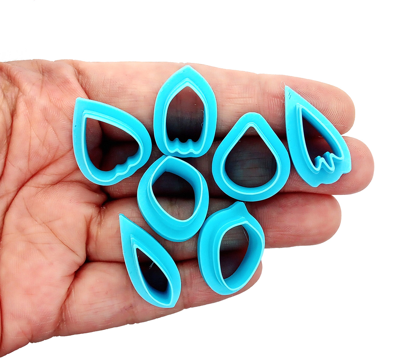 Set of flower petal clay cutters being held in a hand.