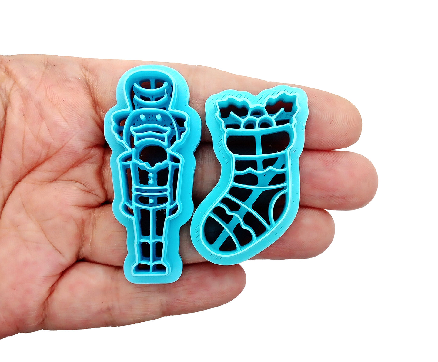 Christmas Clay Cutters: Nutcracker & Stocking in hand, showcasing sturdy sharp blades for polymer clay use.