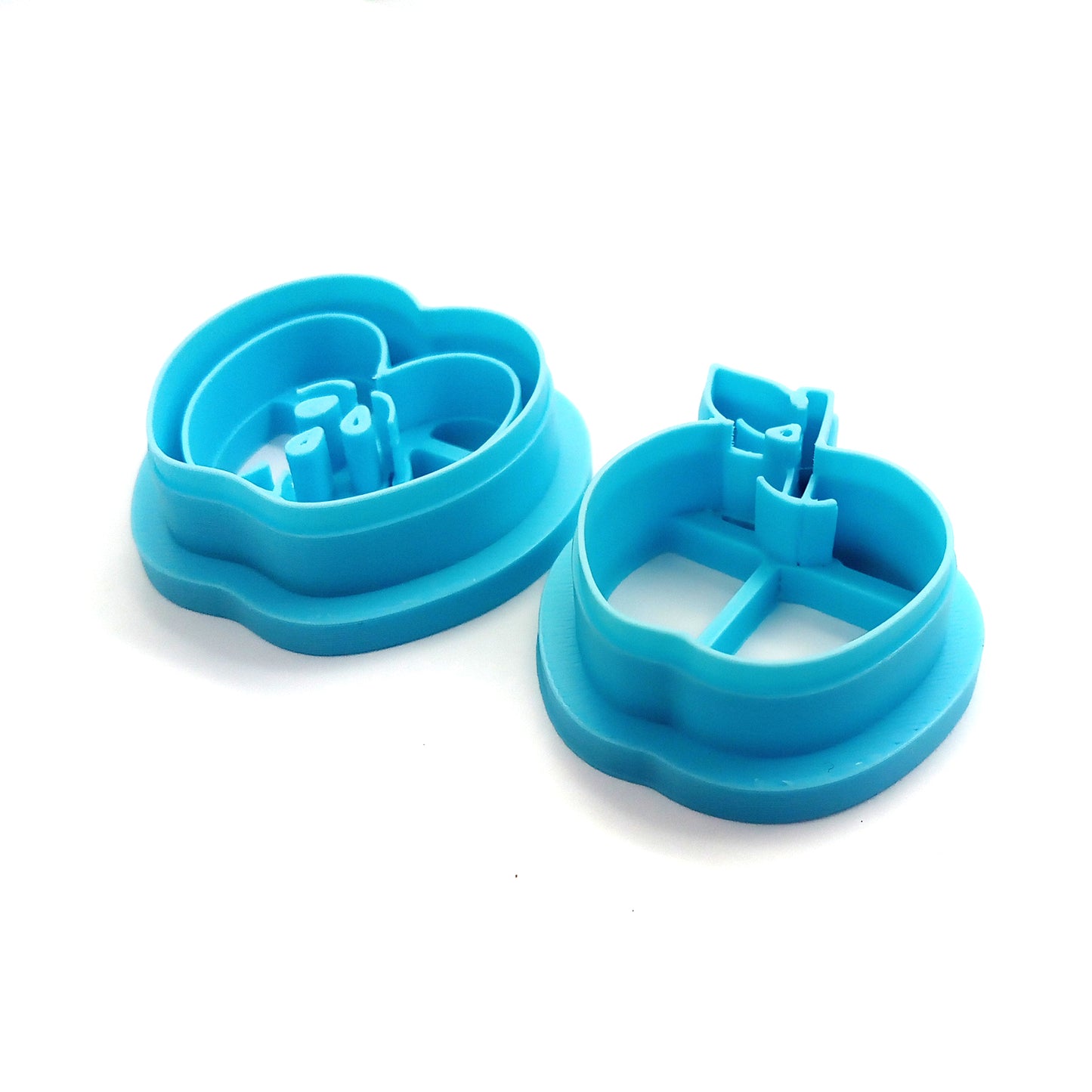 Set of blue clay cutters shaped like apples on a white background
