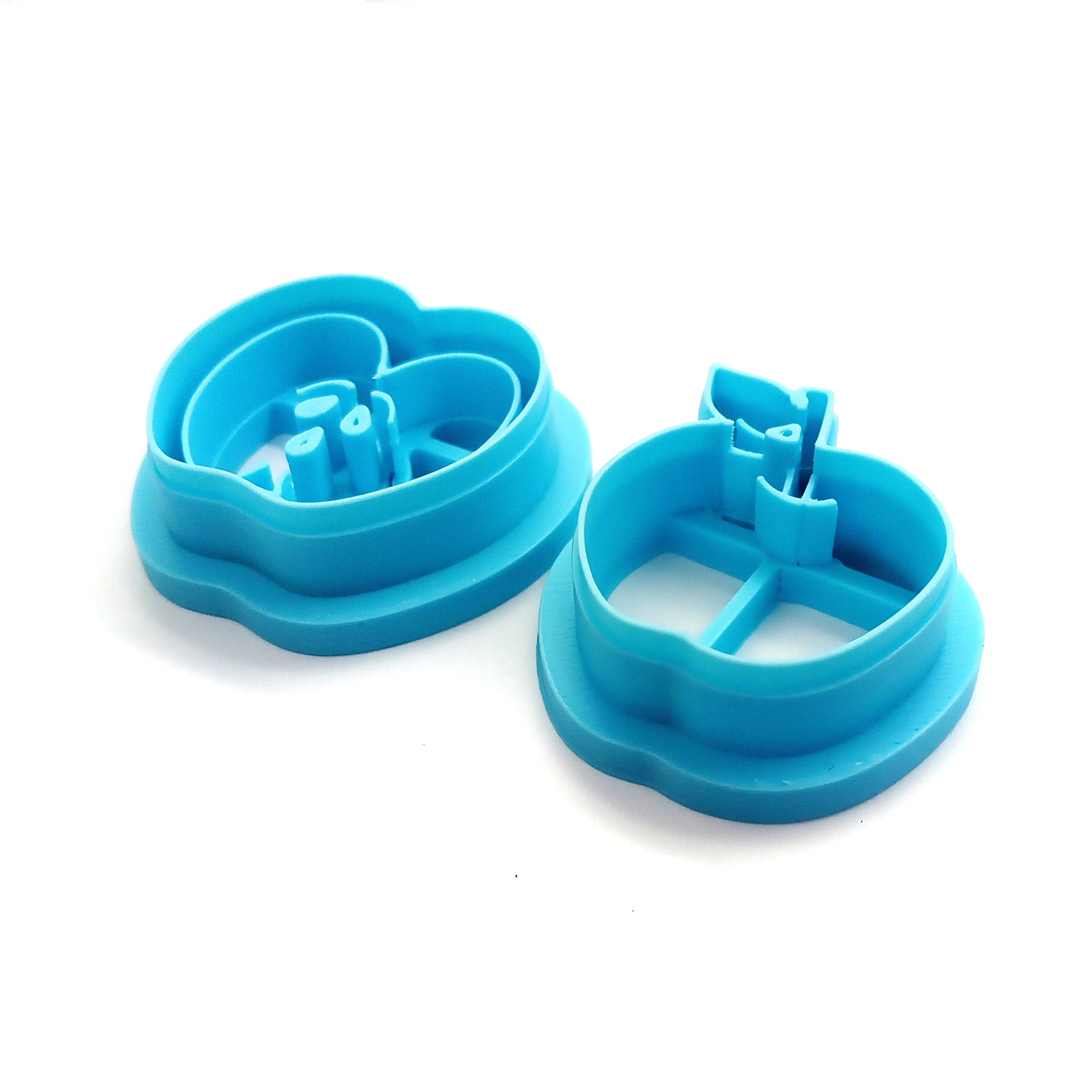 Set of blue clay cutters shaped like apples on a white background