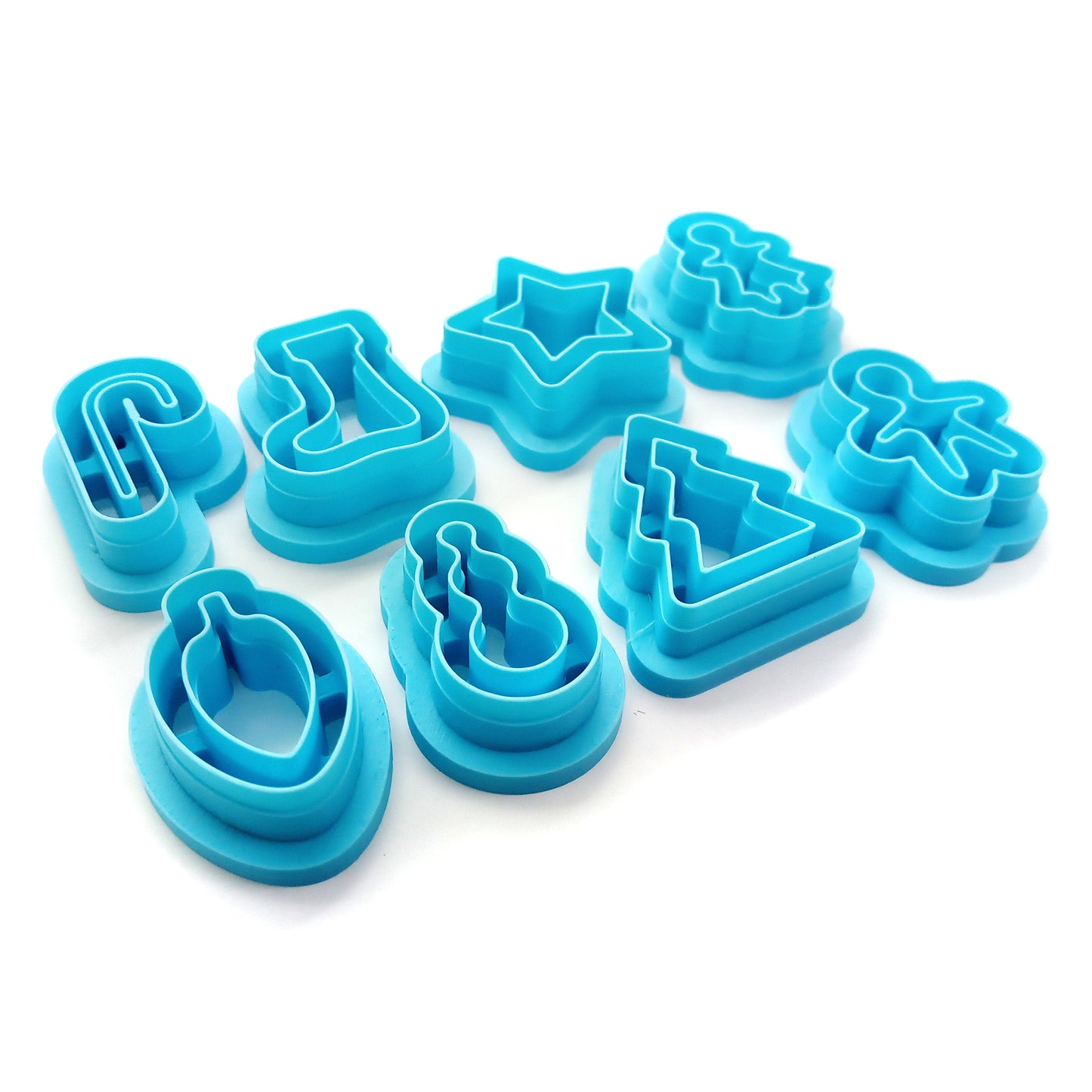 Set of blue clay cutters with various Christmas shapes on a white background