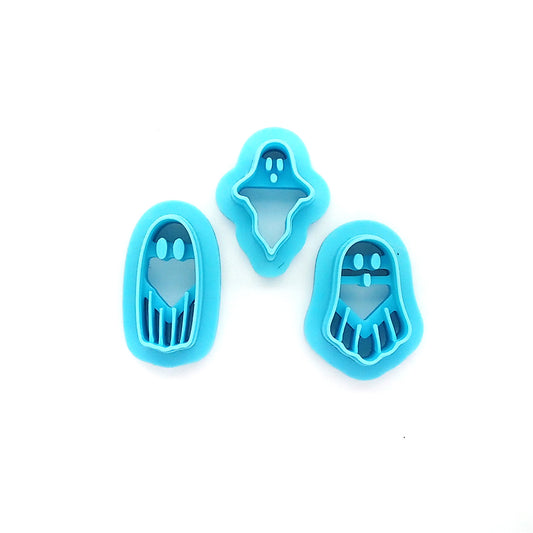 Three blue ghost-shaped clay cutters on a white background