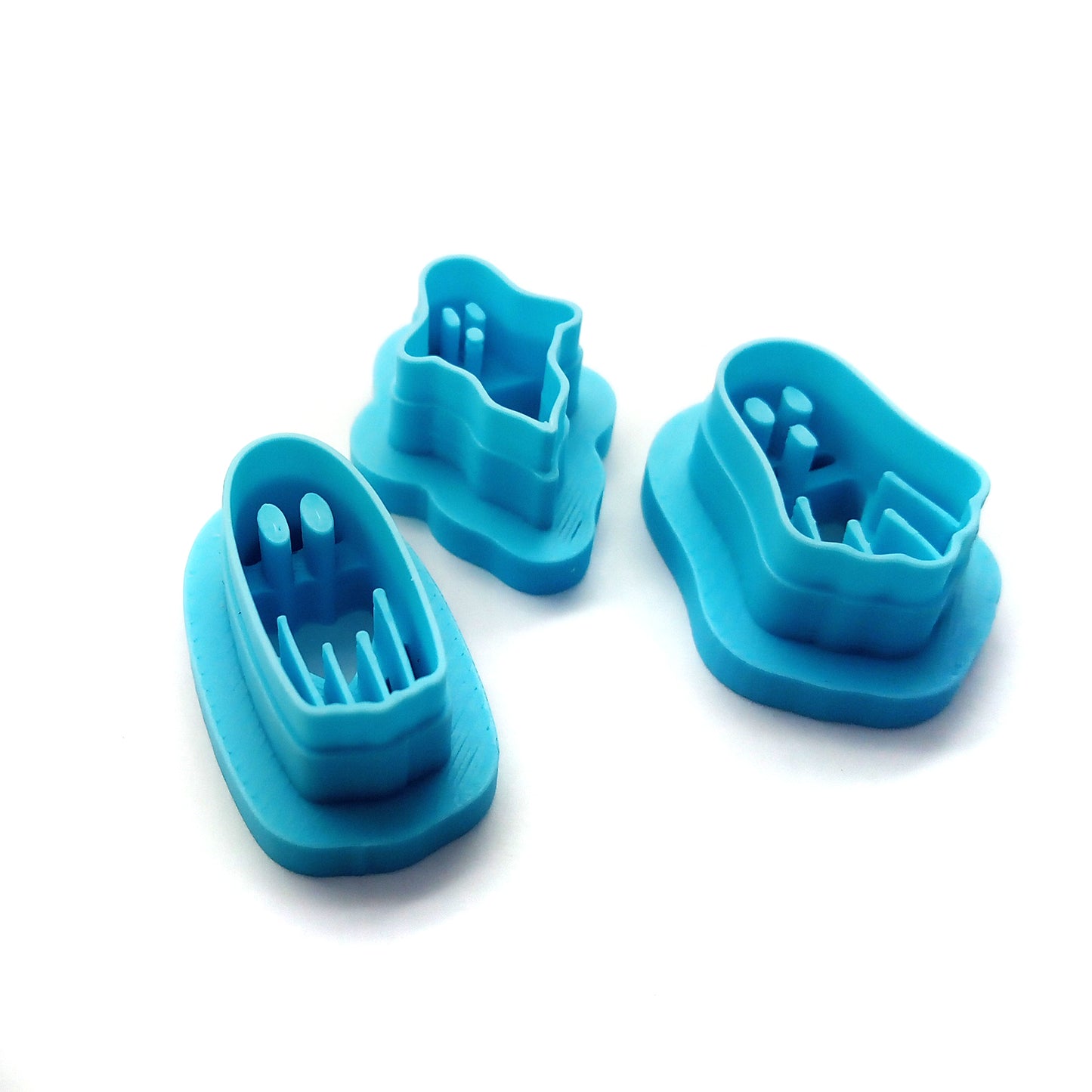 Three blue ghost-shaped clay cutters on a white background