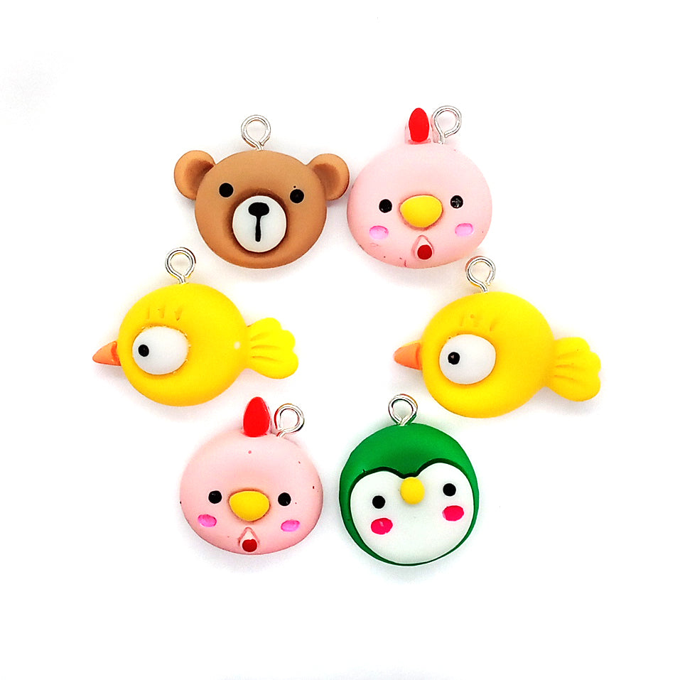 Cute animal face charms made of resin flatback cabochons: green penguin, yellow bird, brown bear and pink chicken.
