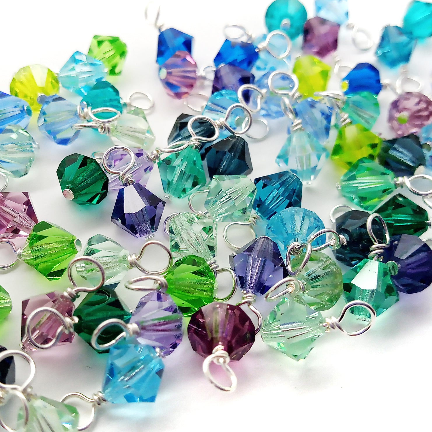 6mm bicone bead dangle charms in Czech glass. Mix of blues, aquas, turquoise, greens, and purples.