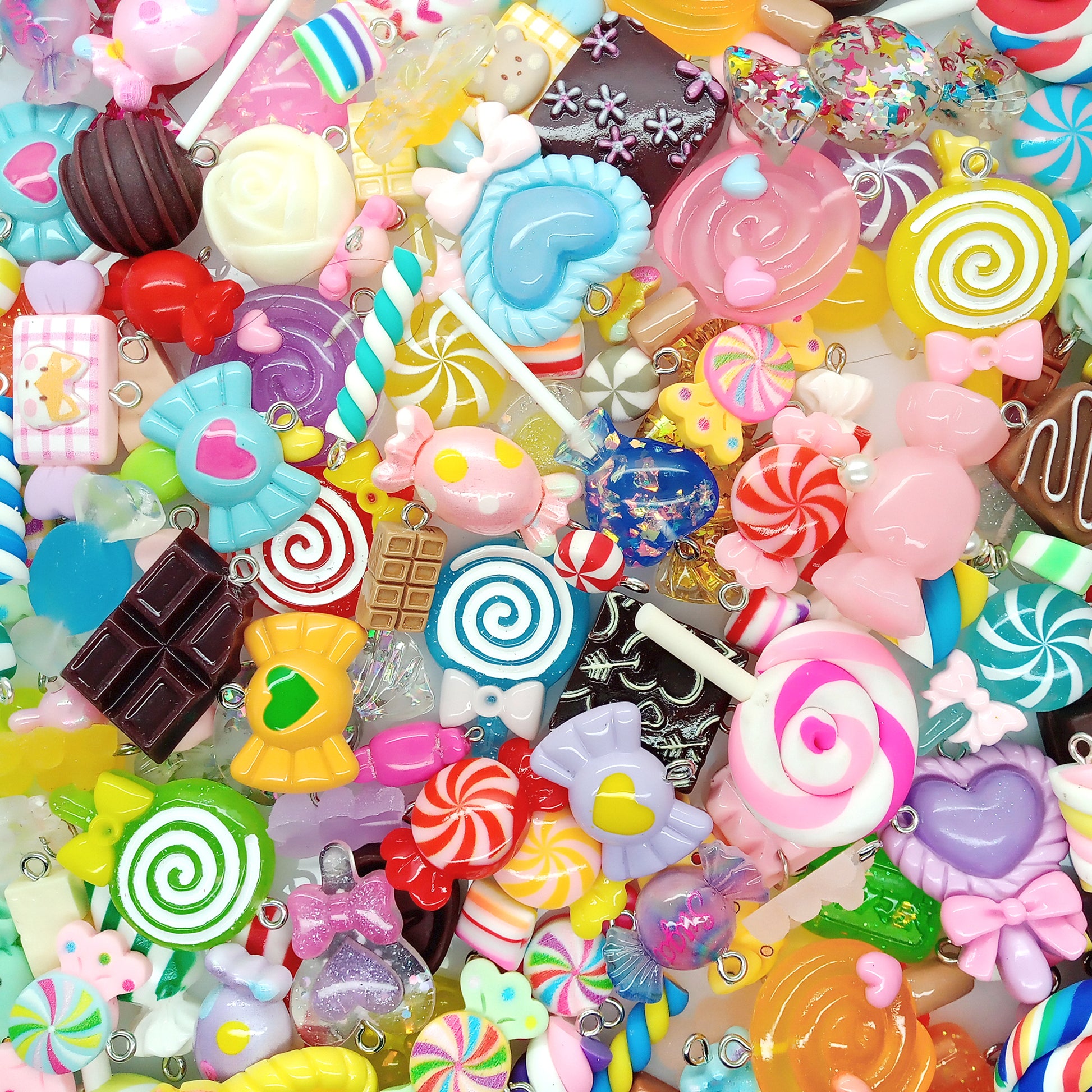 Assorted colorful candy-shaped charms made from resin cabochons, polymer clay and beads.