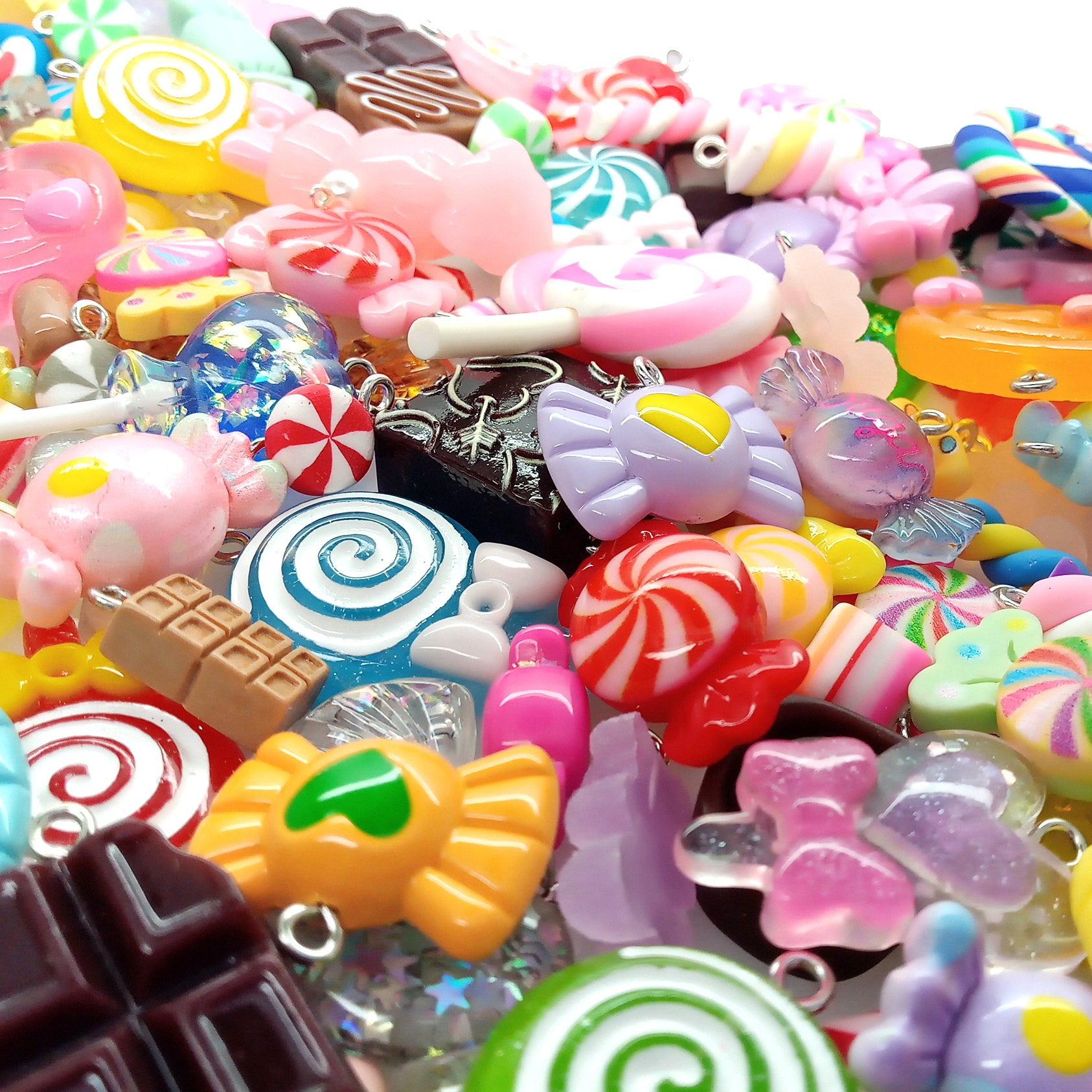 Assorted colorful candy-shaped charms made from resin cabochons, polymer clay and beads.