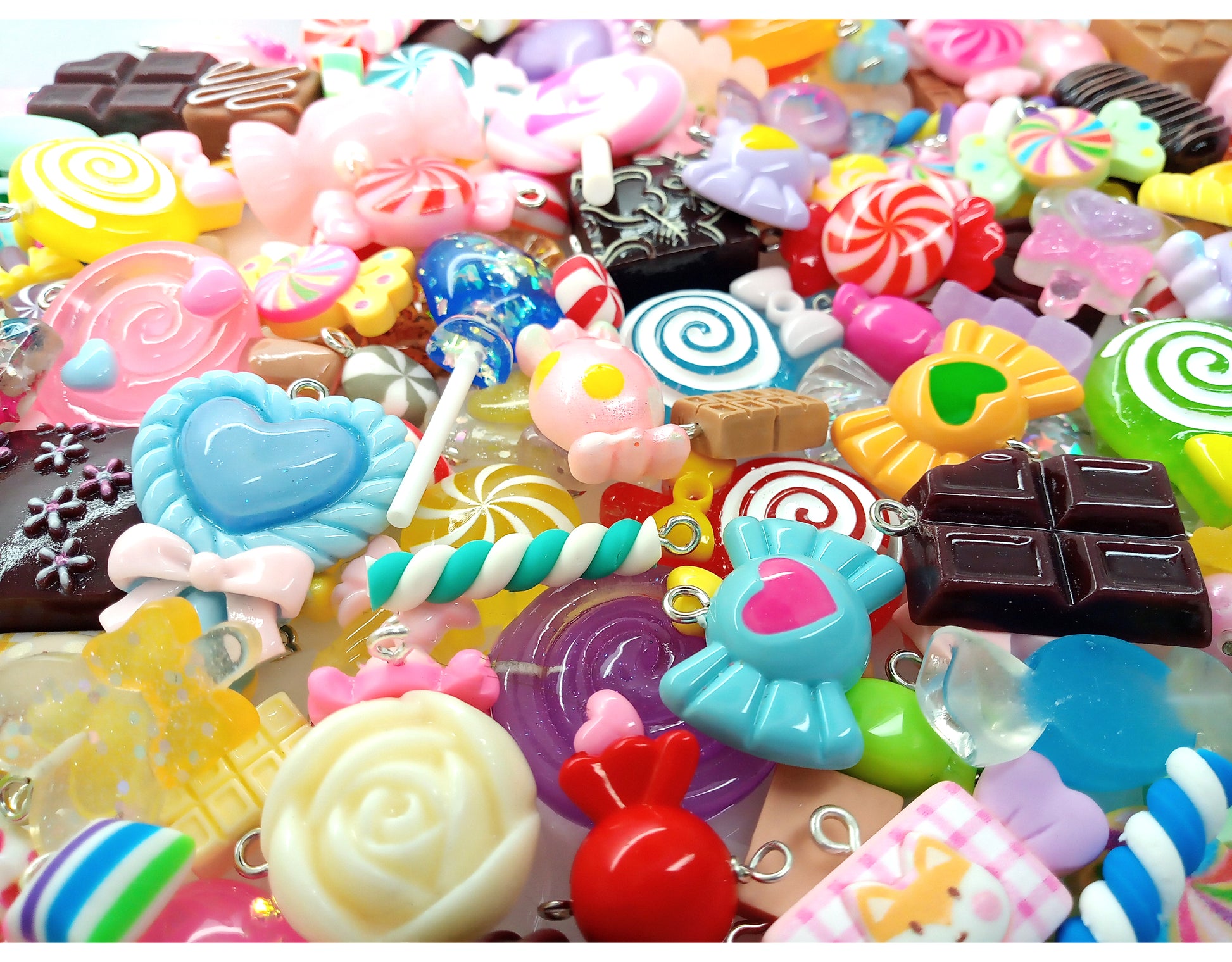 Assorted colorful candy-shaped charms made from resin cabochons, polymer clay and beads.