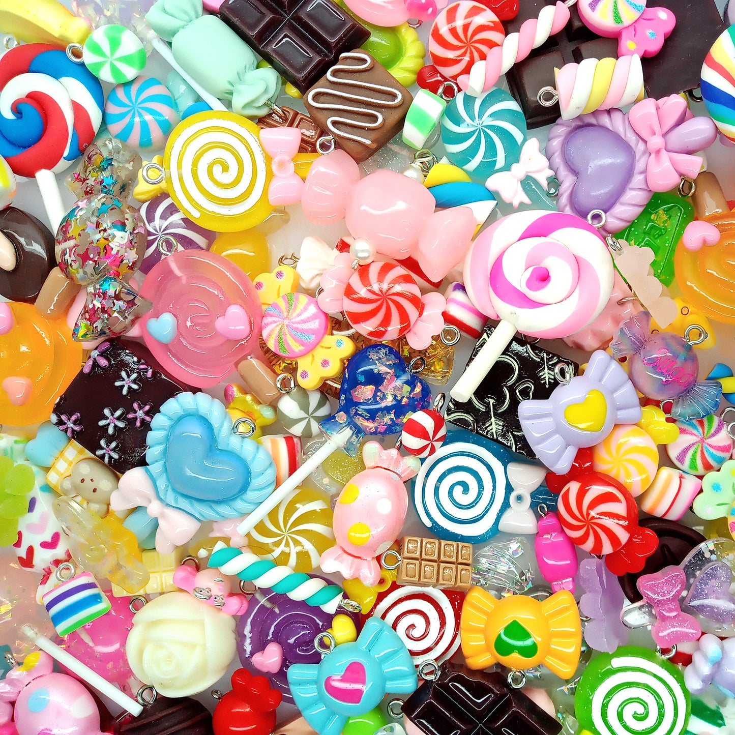 Assorted colorful candy-shaped charms made from resin cabochons, polymer clay and beads.