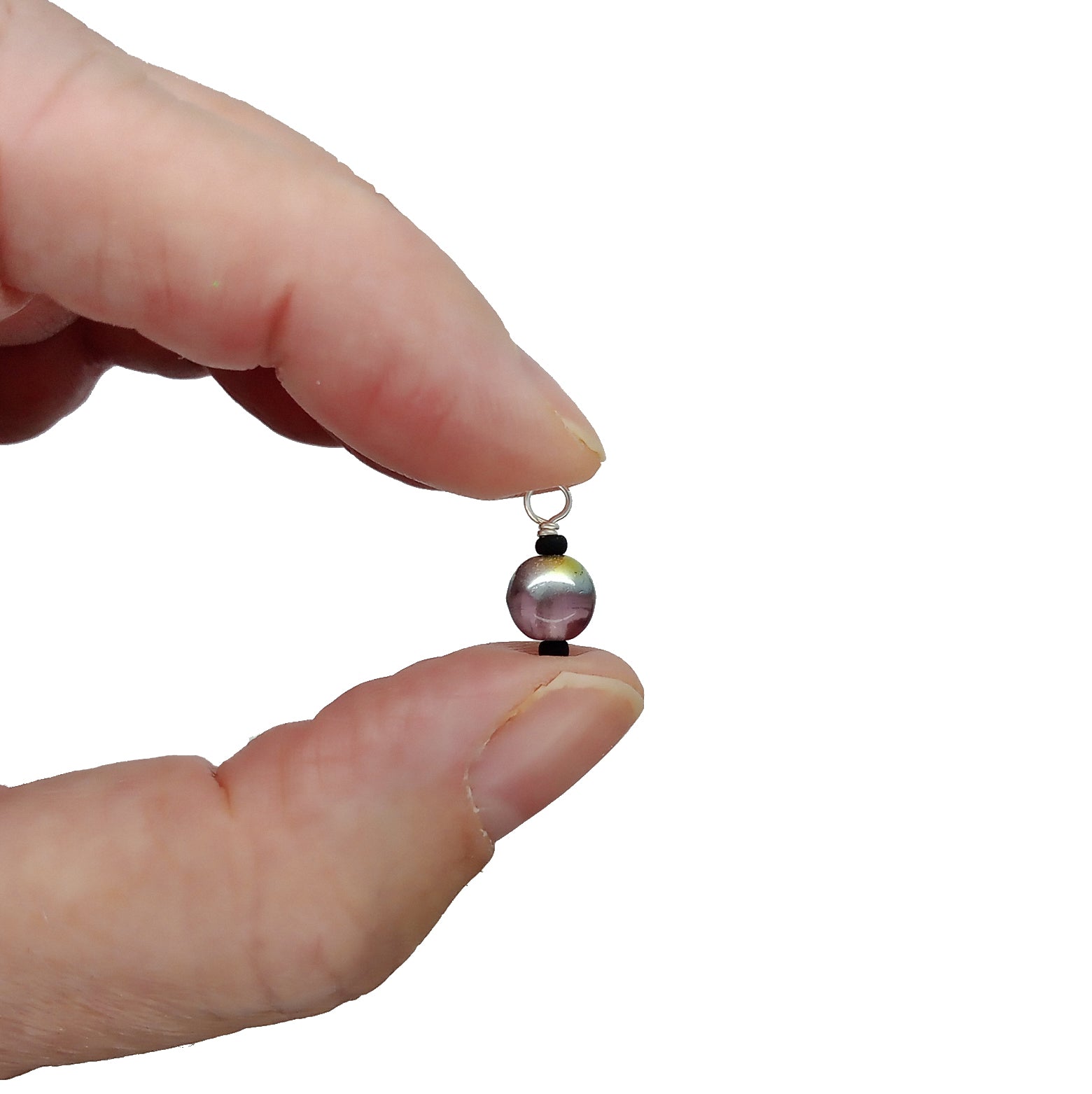 Purple glass bead dangle charm, held in hand.