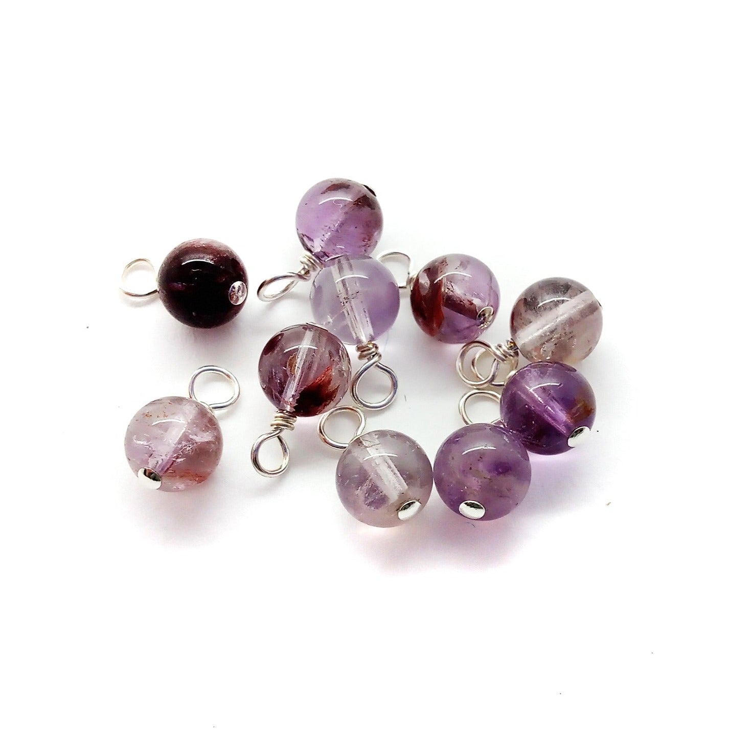 Super Seven 6mm gemstone bead charms, made from a combination of amethyst, cacoxenite, goethite, lepidocrocite, rutile, smoky quartz, and quartz..